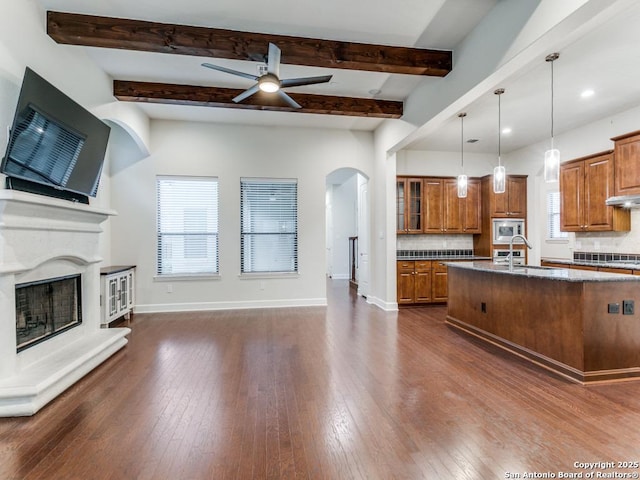 kitchen featuring stainless steel microwave, decorative light fixtures, sink, dark hardwood / wood-style flooring, and ceiling fan