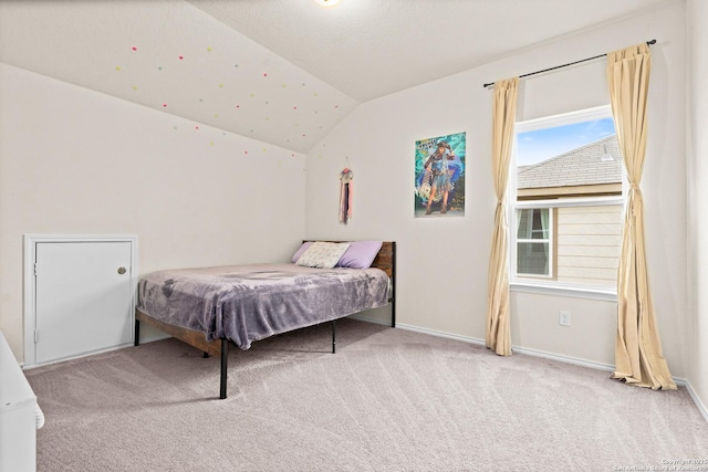 bedroom featuring light colored carpet and vaulted ceiling