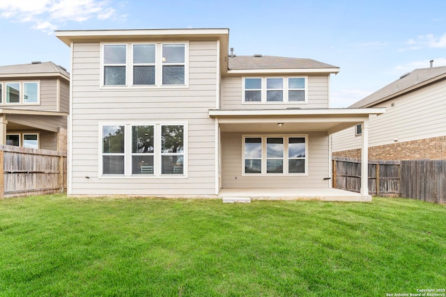 back of house with a patio and a lawn