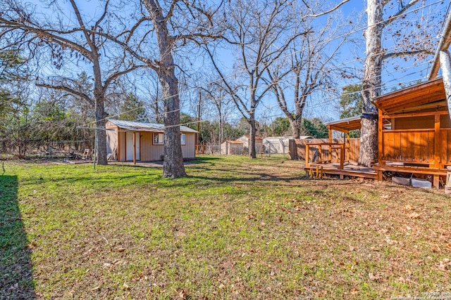 view of yard with a wooden deck and an outbuilding