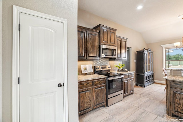 kitchen featuring lofted ceiling, dark brown cabinets, stainless steel appliances, tasteful backsplash, and light stone countertops