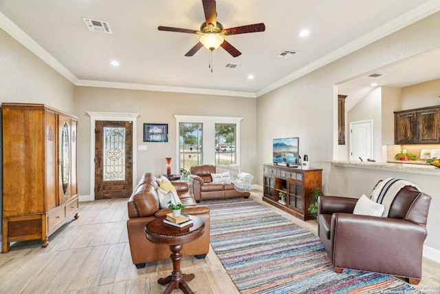 living room featuring ceiling fan, ornamental molding, and light wood-type flooring