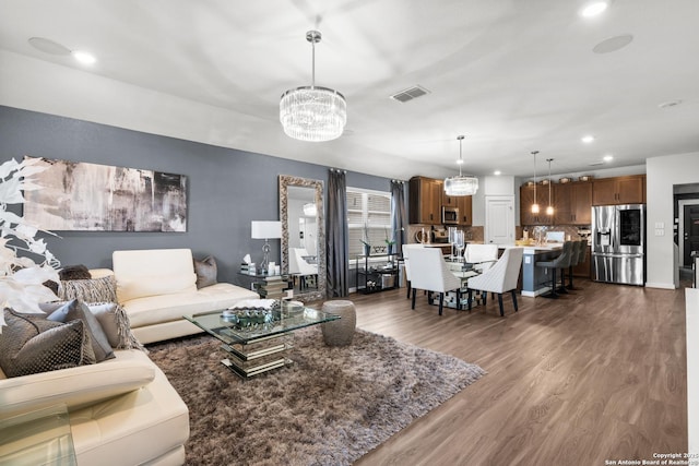 living room featuring an inviting chandelier and dark hardwood / wood-style flooring