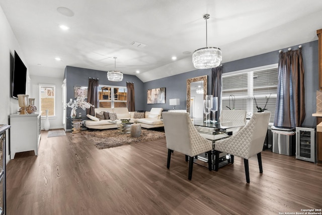 dining area featuring wine cooler, lofted ceiling, dark hardwood / wood-style floors, and a chandelier