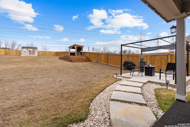 view of yard featuring a patio, an outdoor fire pit, a gazebo, and a storage shed