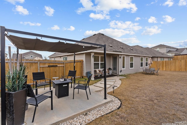 rear view of property with a pergola, a patio area, and an outdoor fire pit