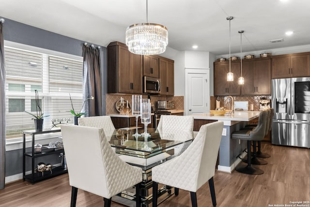 dining space featuring a notable chandelier and wood-type flooring