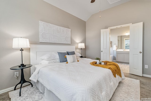 carpeted bedroom with ceiling fan, sink, connected bathroom, and vaulted ceiling