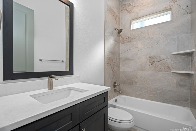 full bathroom featuring tiled shower / bath, vanity, and toilet