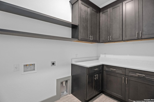 clothes washing area with cabinets, washer hookup, light hardwood / wood-style flooring, and electric dryer hookup