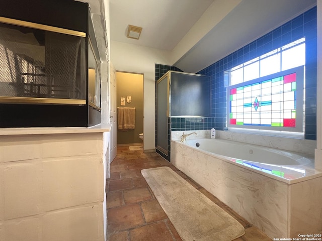 bathroom featuring separate shower and tub and toilet