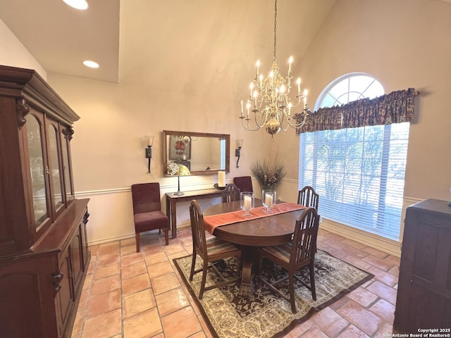 dining space featuring high vaulted ceiling and a chandelier