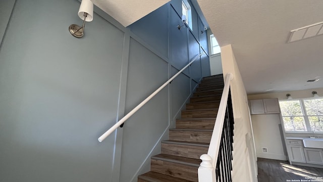 staircase with sink and hardwood / wood-style flooring