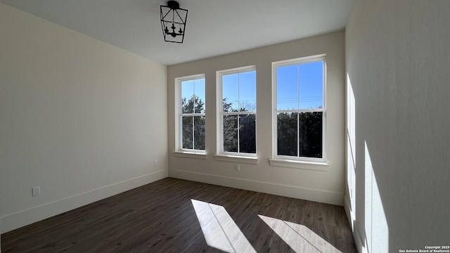 unfurnished room with dark wood-type flooring