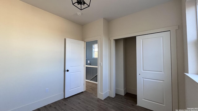 unfurnished bedroom featuring a closet and dark hardwood / wood-style floors