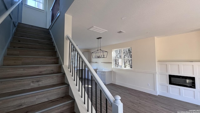 staircase featuring wood-type flooring and a textured ceiling