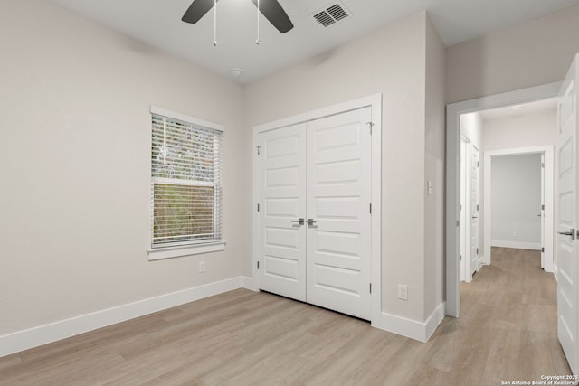 unfurnished bedroom featuring light hardwood / wood-style flooring, a closet, and ceiling fan