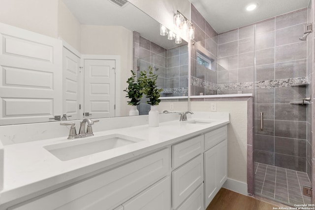 bathroom with vanity, hardwood / wood-style flooring, and a shower with door