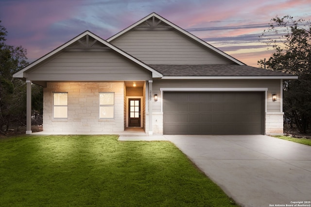 view of front of property with a garage and a lawn