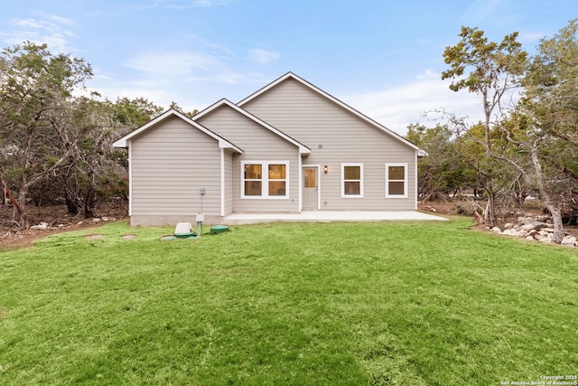 rear view of house featuring a patio area and a lawn