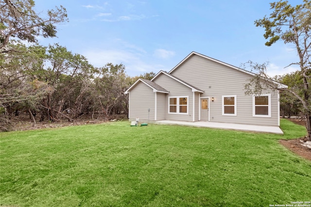 rear view of property featuring a yard and a patio