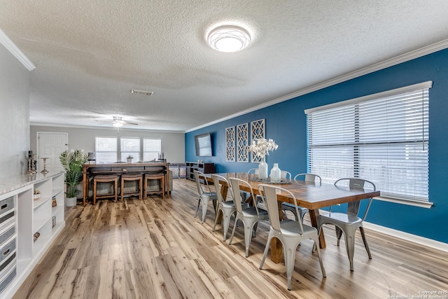 dining area featuring ornamental molding and light hardwood / wood-style floors