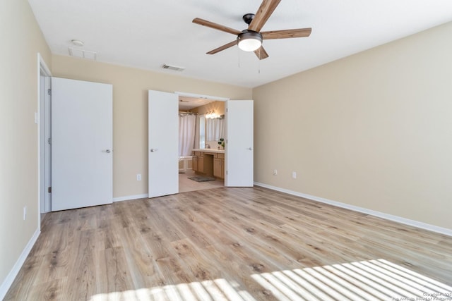 unfurnished bedroom featuring ceiling fan, ensuite bath, and light wood-type flooring