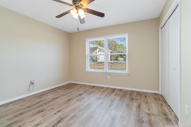 unfurnished bedroom featuring ceiling fan, a closet, and light wood-type flooring