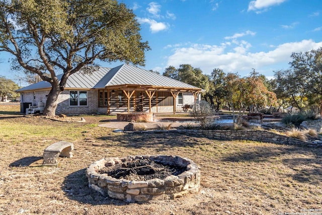 rear view of house featuring a fire pit