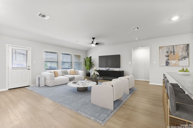 living room featuring light hardwood / wood-style flooring and ceiling fan