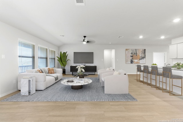 living room featuring ceiling fan and light wood-type flooring