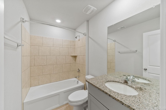 full bathroom with tiled shower / bath, vanity, and toilet