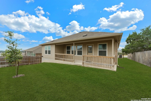 rear view of house with a lawn and a porch