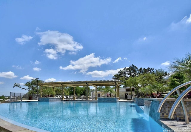 view of pool with a pergola and pool water feature