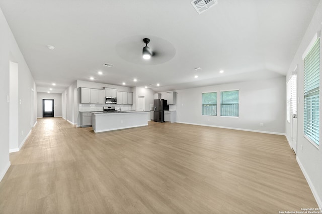 unfurnished living room featuring ceiling fan and light hardwood / wood-style floors