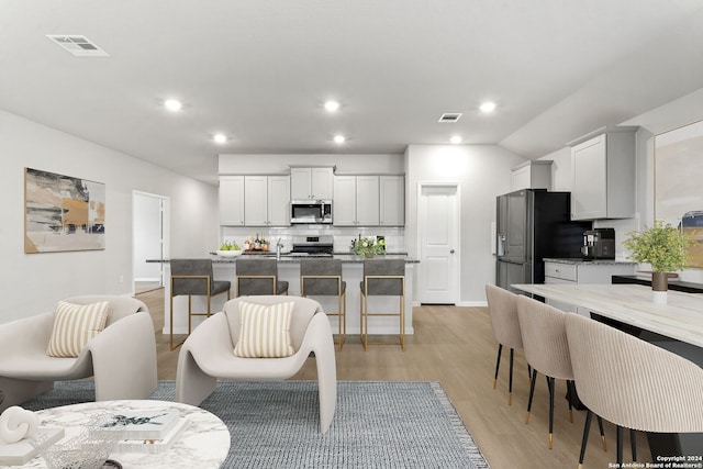 living room with sink and light hardwood / wood-style flooring