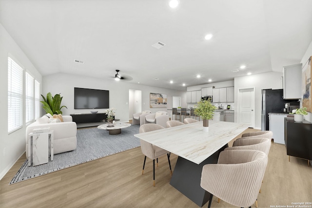 dining room with vaulted ceiling, ceiling fan, and light hardwood / wood-style floors