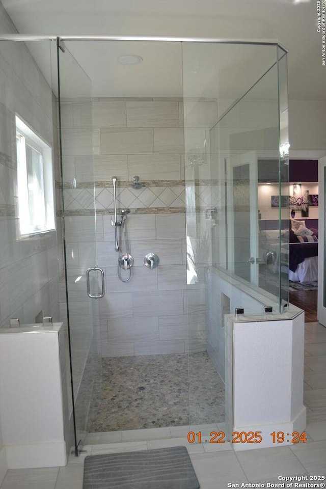 bathroom with a shower with door