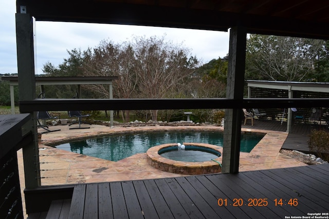 view of pool featuring an in ground hot tub and a deck