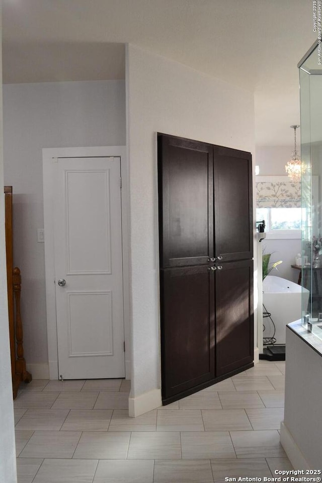 interior space featuring hanging light fixtures, dark brown cabinets, and a chandelier