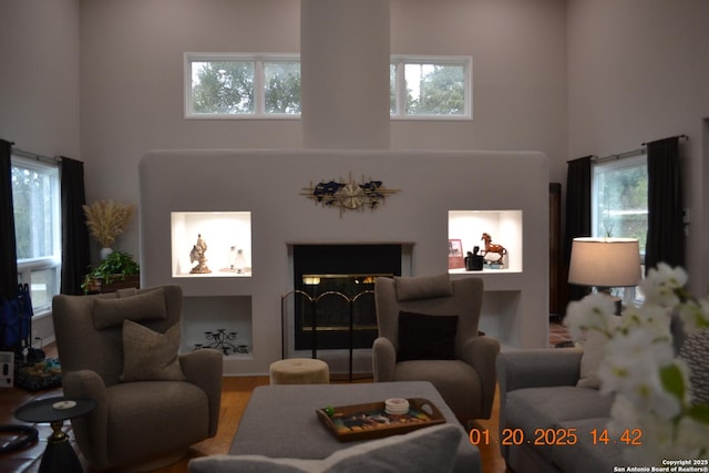 living room with wood-type flooring and a high ceiling