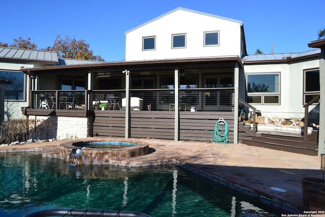 back of house with a swimming pool with hot tub and a patio area