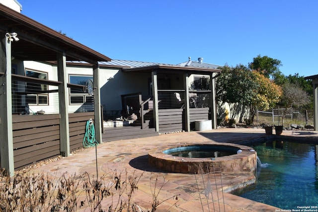 rear view of property with a swimming pool with hot tub, a patio, a sunroom, and pool water feature