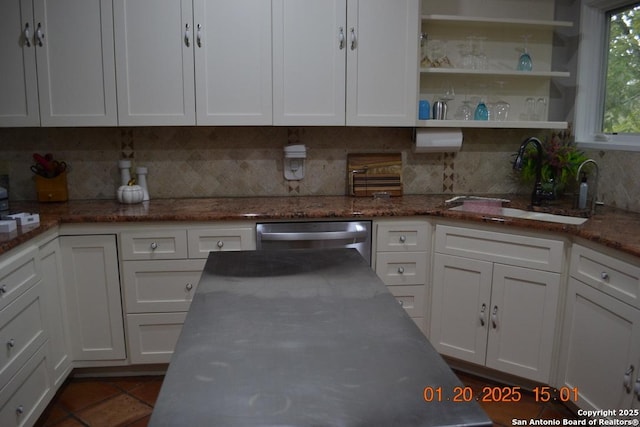 kitchen with stainless steel dishwasher, stone countertops, sink, and white cabinets