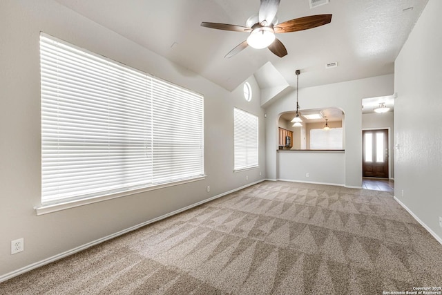 unfurnished living room with ceiling fan, lofted ceiling, and light carpet