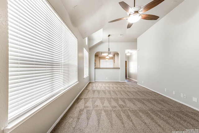 unfurnished living room with vaulted ceiling, light colored carpet, and ceiling fan