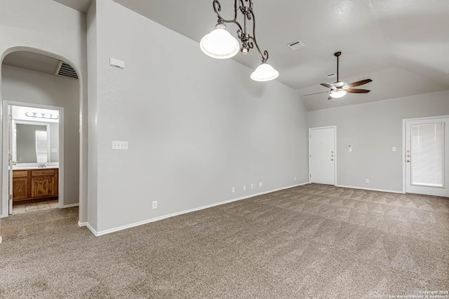 unfurnished room with vaulted ceiling, light colored carpet, and ceiling fan