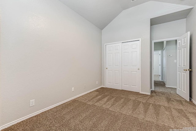 unfurnished bedroom featuring lofted ceiling, carpet floors, and a closet