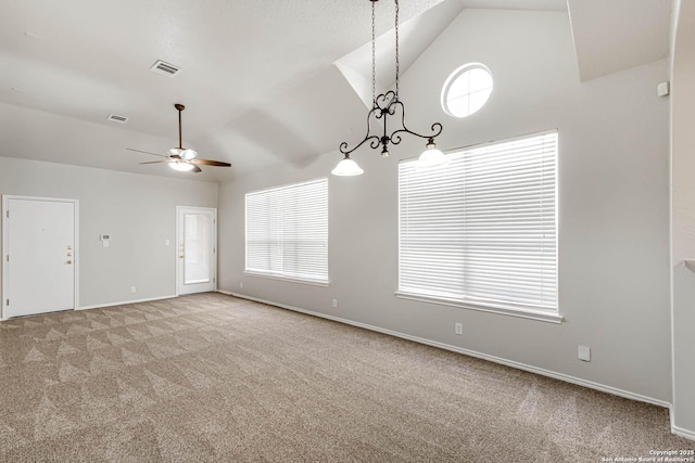 carpeted empty room featuring ceiling fan, a healthy amount of sunlight, and vaulted ceiling