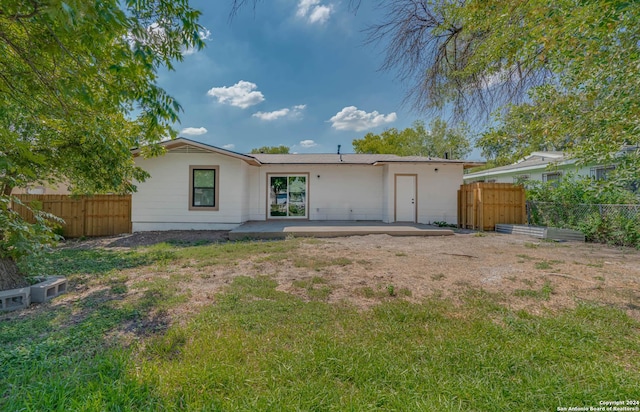 rear view of house with a yard and a patio area